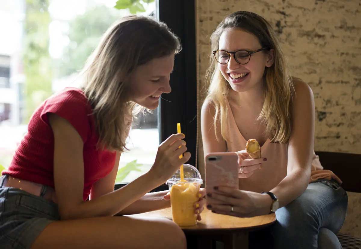 Students having a snack and looking at phone